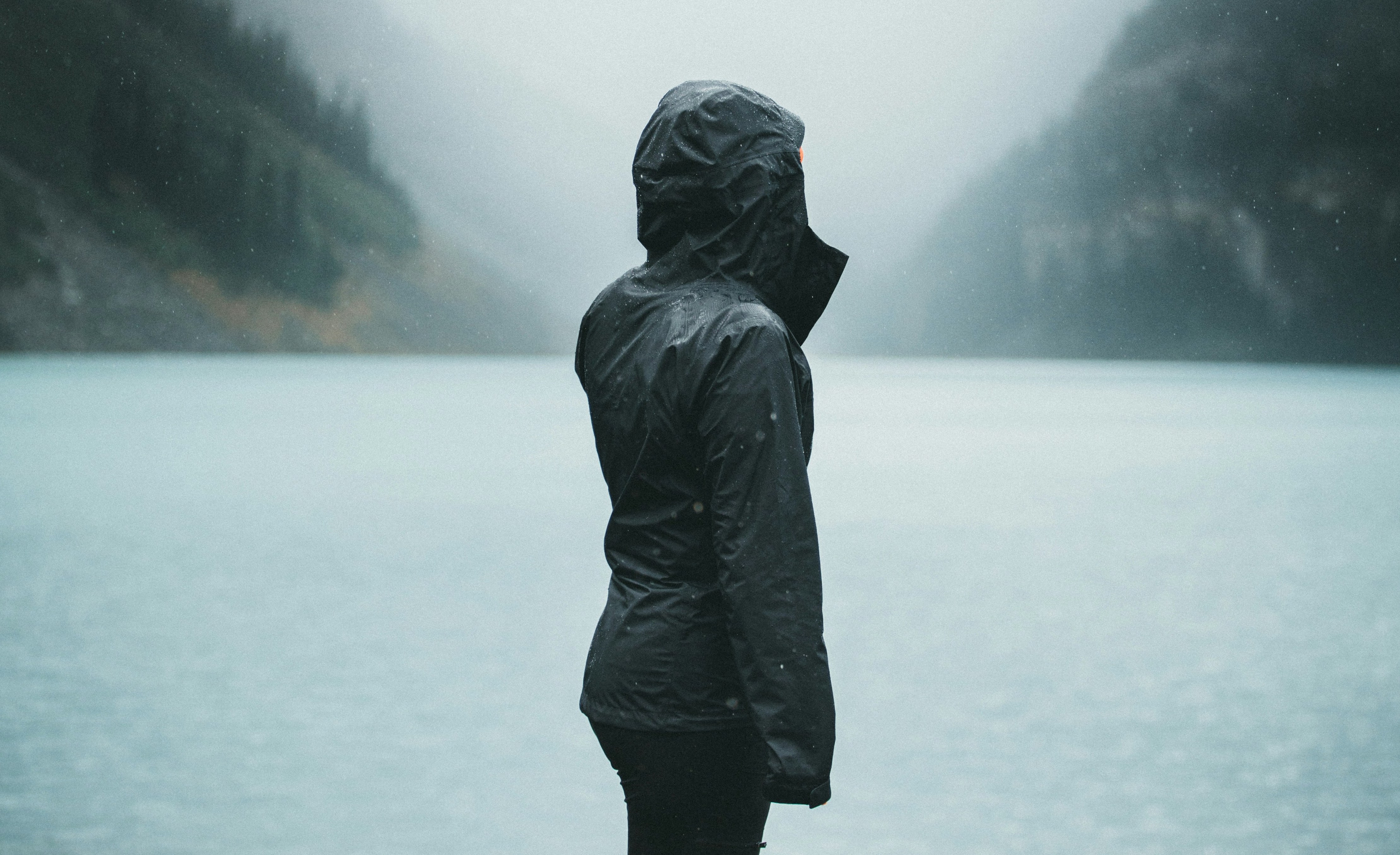 woman standing on pier with mountains in background